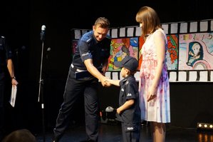 policjant gratuluje wyróżnionemu przedszkolakowi