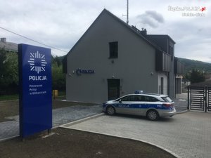 Posterunek Policji w Wilkowicach-widok z zewnątrz na boczna stronę wykończonego budynku i zaparkowany radiowóz oznakowany