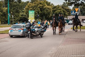 Zabezpieczenie meczu w Tychach. Policjanci na koniach służbowych, radiowóz oznakowany oraz 2 motocykle