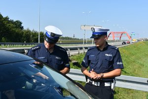 Policjanci kontrolują samochód podczas akcji Bezpieczny weekend - ostatni weekend wakacji.
