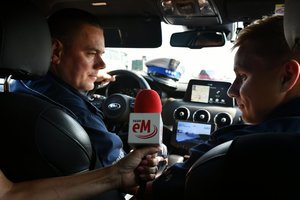 Policjanci rozmawiają z dziennikarką radiową podczas akcji Bezpieczny weekend - ostatni weekend wakacji.