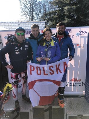 Zdjęcie kolorowe. Widoczna policjanta i 3 policjantów wchodzących w skład zwycięskiej drużyny narciarskiej reprezentacji Policji Polskiej