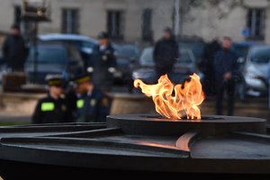Zapalony znicz pod pomnikiem Marszałka