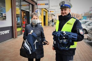 Wspólne zdjęcie policjanta i kobiety, która otrzymała od niego odblaskową torbę.