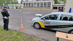 Policjant nadzoruje konkurencję testu stewarda samochodem osobowym
