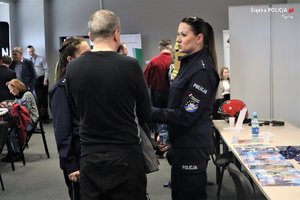 Na zdjęciu policjantka w trakcie targów pracy na specjalnie przygotowanym stanowisku, rozmawia z osobami zainteresowanymi służbą w Policji.