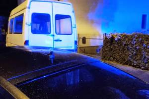 zdjęcie- noc, zatrzymany dostawczy samochód, niebieskie światło odbijające się od ścian budynku