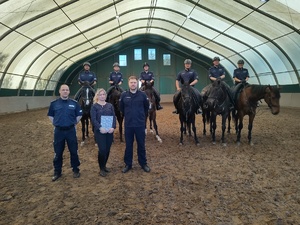 Wspólne pamiątkowe zdjęcie policyjnych jeźdźcy i koni służbowych