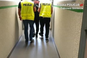 Policjanci prowadzą zatrzymanego