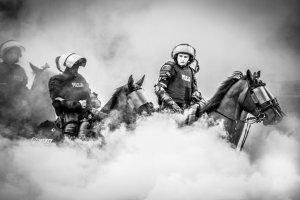 Zdjęcie czarno-białe. Przedstawiające policjantów na koniach.