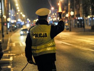 policjant RD zatrzymuje w nocy latarką pojazd do kontroli