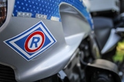 zdjęcie kolorowe: znak wydziału ruchu drogowego umieszczony na policyjnym motorze