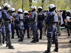 zdjęcie kolorowe: policjanci oddziału prewencji nadzorujący przemarsz kibiców