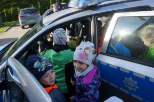 Na fotografii widać uczniów SP nr 3 w Orzeszu w trakcie wizyty w Komisariacie Policji w Orzeszu w dniu 10.10. 2019 r. - Dni Otwarte jednostki policji. Dzieci oglądają radiowóz policjantów.