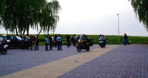 Fotografia kolorowa. Na zdjęciu zaparkowane pod Kopcem Wyzwolenia motocykle oraz osoby zbierające się na starcie imprezy.