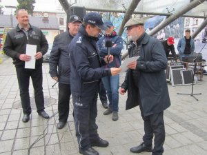 Obrazek przedstawia  Komendanta Miejskiego Policji w Tychach insp. Andrzeja Trzcińskiego składającego podziękowania Burmistrzowi Miasta Ustroń, na scenie widoczne inne osoby