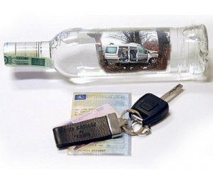 Na zdjęciu widoczna butelka alkoholu oraz kluczyki z samochodu