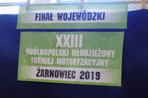 Zdjęcie zawieszonego na ścianie baneru z napisem „finał wojewódzki XXIII ogólnopolski młodzieżowy turniej motoryzacyjny 2019”.